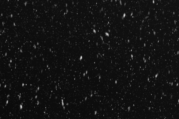 a black and white photo of snow falling