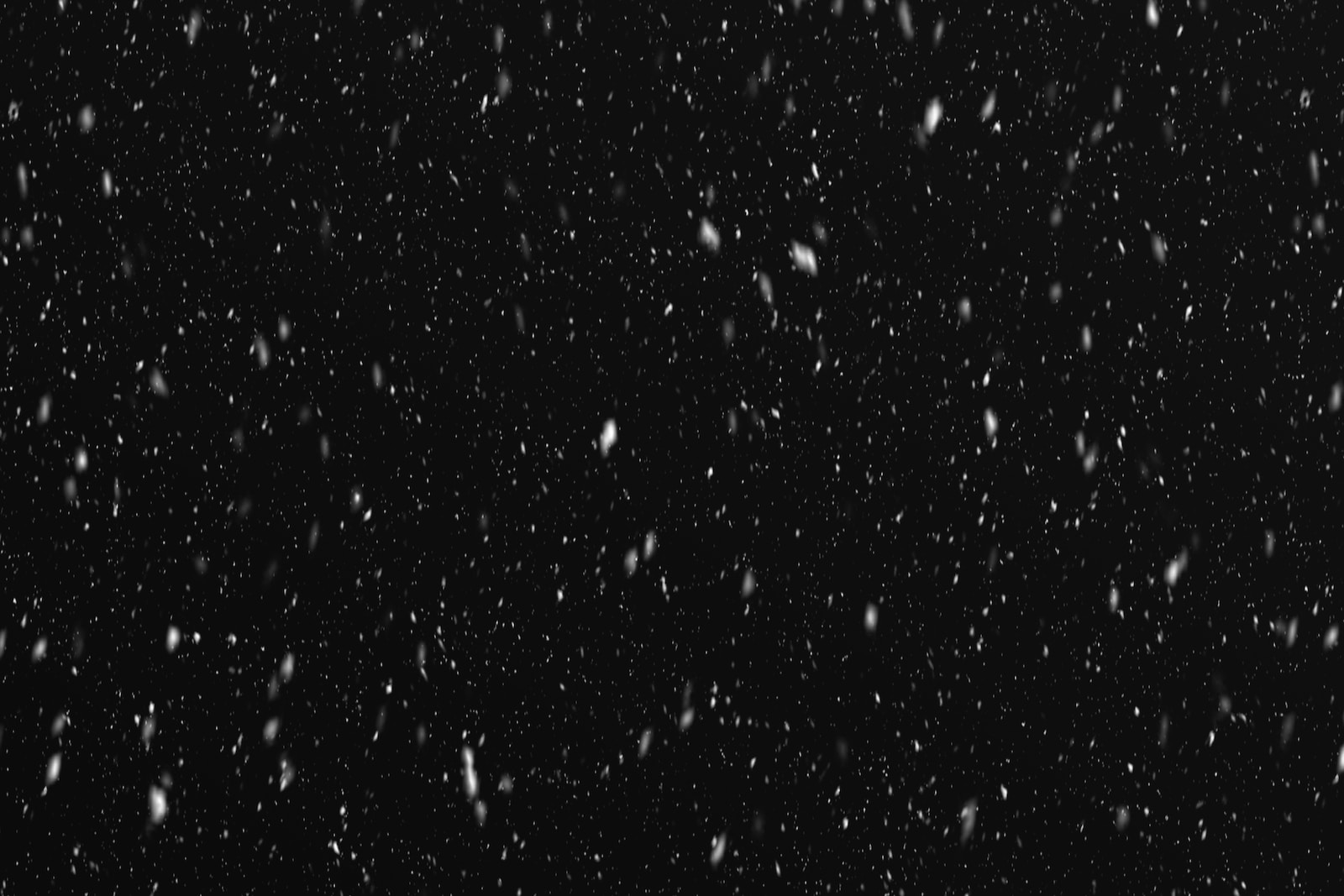a black and white photo of snow falling