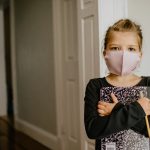woman in black cardigan wearing white mask