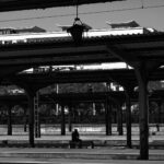 a person sitting on a bench in a train station