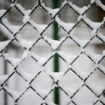 snow covered black steel fence