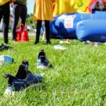 a group of people standing in a grassy area with a blue object in the back