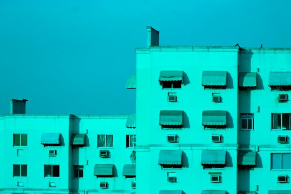a tall white building with many windows and a sky background