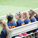 girls sitting on bench during daytime